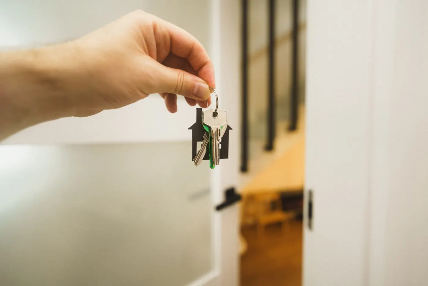 A hand turning the key in the front door of a new house